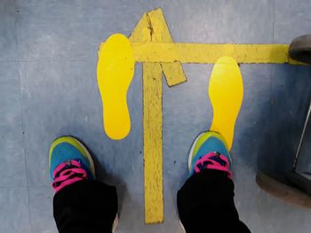 Low section of person standing on yellow floor