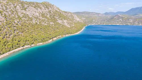 Scenic view of sea and mountains against sky