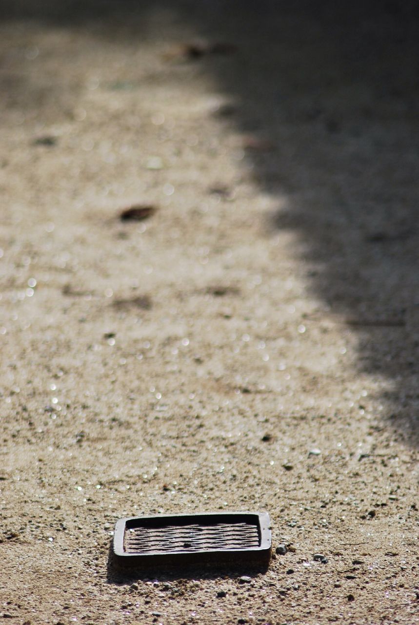 communication, text, high angle view, close-up, street, western script, sand, asphalt, no people, road, day, outdoors, still life, beach, single object, ground, guidance, sign, absence, capital letter