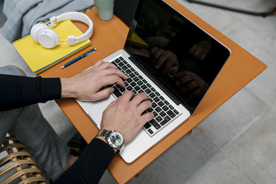 Businessman using laptop on table while sitting at cafe