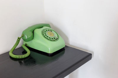 High angle view of telephone on table against wall