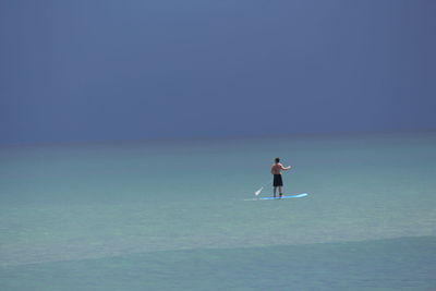 Man standing in sea against clear sky