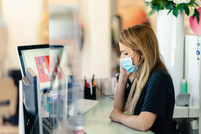 Woman wearing mask sitting at office