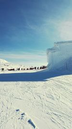 Panoramic view of people on beach against blue sky