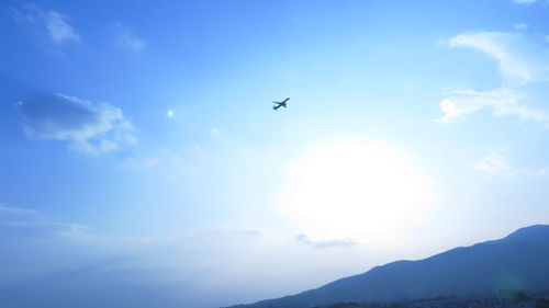 Low angle view of airplane flying against blue sky