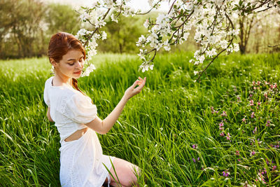 Portrait of young woman sitting on grass