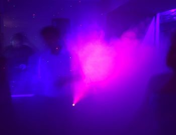 Group of people dancing in nightclub at night