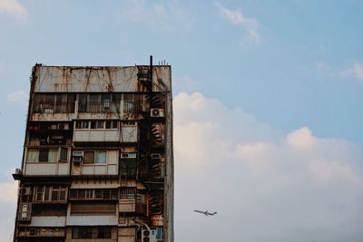 Low angle view of building against cloudy sky