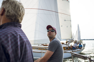 Rear view of friends on boat against sea