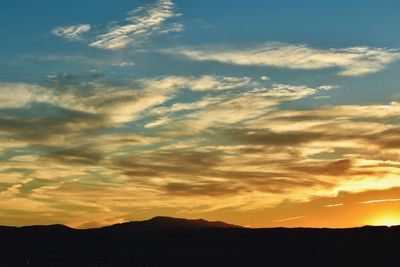 Scenic view of silhouette mountains against sky at sunset