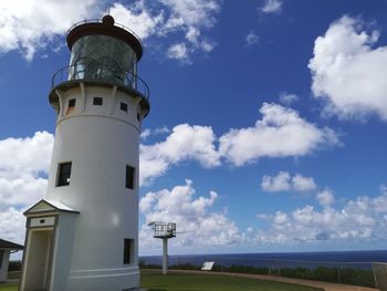 Low angle view of lighthouse amidst buildings against sky