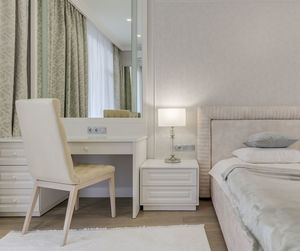 Close-up bright bedroom with bed, large mirror and dressing table