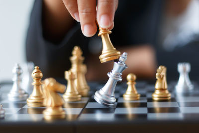 Close-up of businesswoman playing with chess at desk