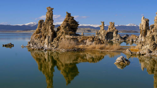 Panoramic view of lake and rocks against blue sky