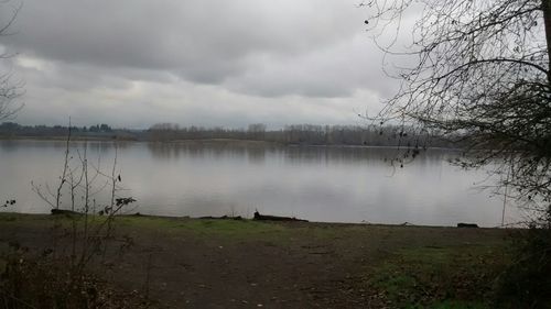 Scenic view of calm lake against cloudy sky