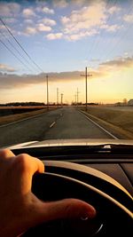 Road seen through car windshield during sunset