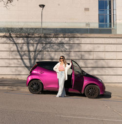 Woman with umbrella standing in car