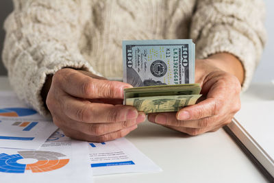 Close-up of woman holding paper with text on table