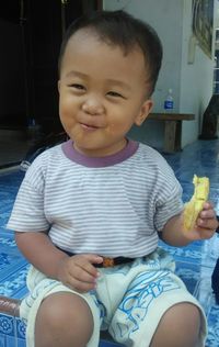 Cute baby boy sitting in front of woman