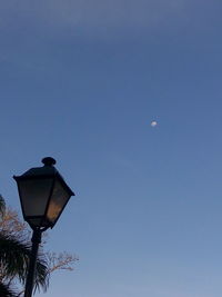 Low angle view of street light against blue sky