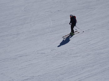 Side view of person skiing on snow covered field