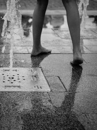 Low section of person playing at water fountain