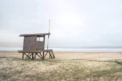 Lifeguard hut on beach against sky