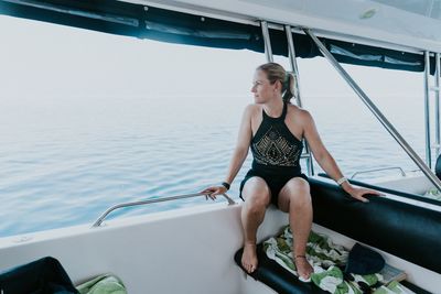 Mature woman sitting on boat sailing in sea