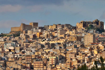 Aerial view of buildings in town against sky