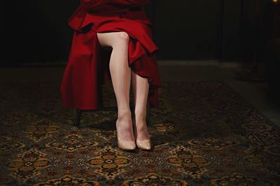 Low section of woman relaxing on tiled floor