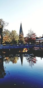 Scenic view of river by buildings against clear sky