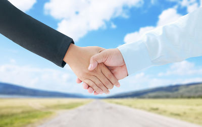 Close-up of hand against sky