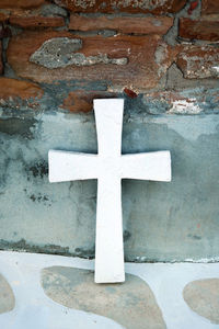 Close-up of cross on white wall