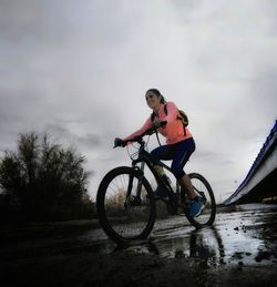 Man riding bicycle on puddle
