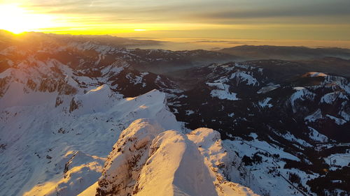 Scenic view of snowcapped mountains against sky during sunset