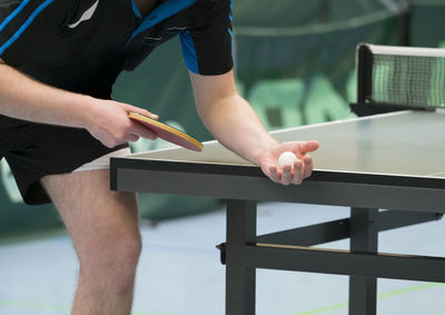 Midsection of man playing table tennis
