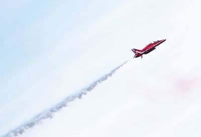 Low angle view of airplane flying against sky