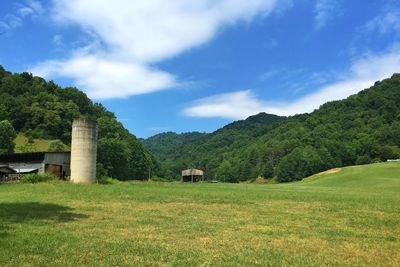 Scenic view of grassy field against cloudy sky