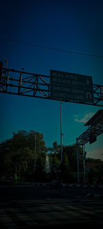 Low angle view of sign against blue sky