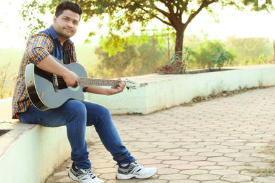 Full length of man playing guitar