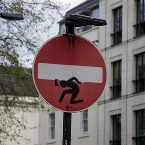 Close-up of road sign against sky