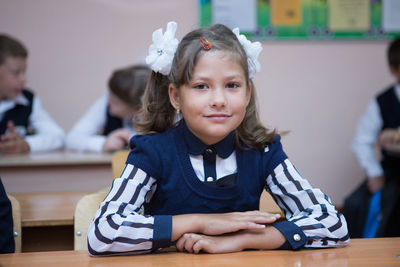 Portrait of a smiling girl sitting on table