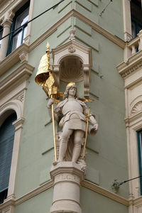 Low angle view of statue against historic building