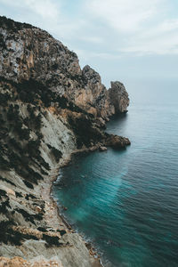 Rock formations by sea against sky