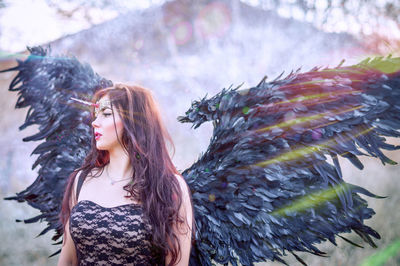 Close-up of beautiful young woman wearing angel costume