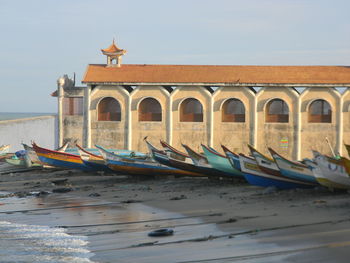 Boats moored on shore against sky