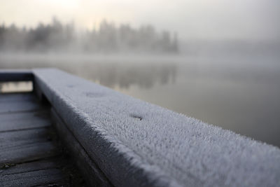 Close-up of pier over lake during winter