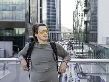 Young woman wearing sunglasses standing in city