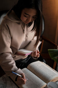 Side view of young woman sitting at home