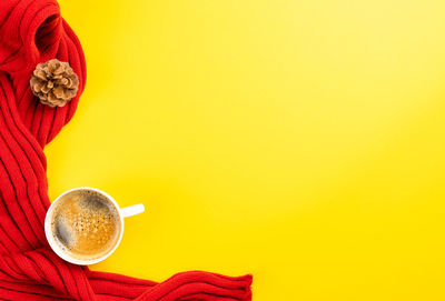 Directly above shot of coffee cup against yellow background